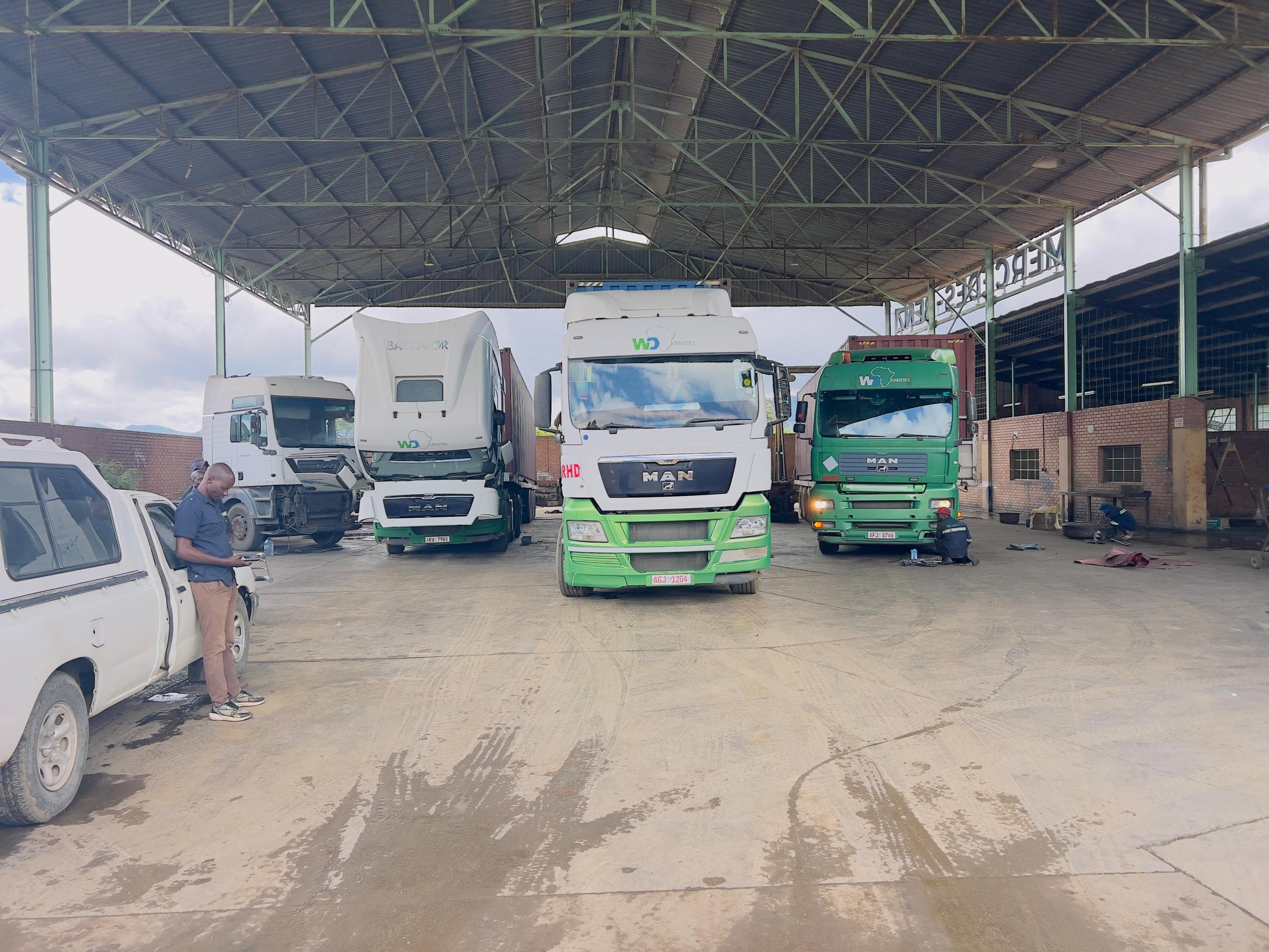 WD Logistics trucks parked under the workshop shed at the Nyakamete yard